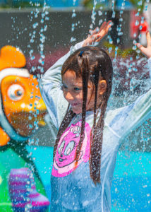 Niña feliz jugando en un Splash Pad de Amusement Logic